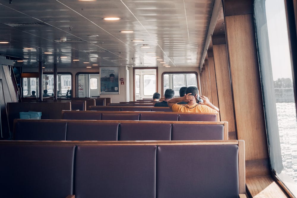 Interior of a passenger ferry with rows of seats and travelers heading to Cozumel